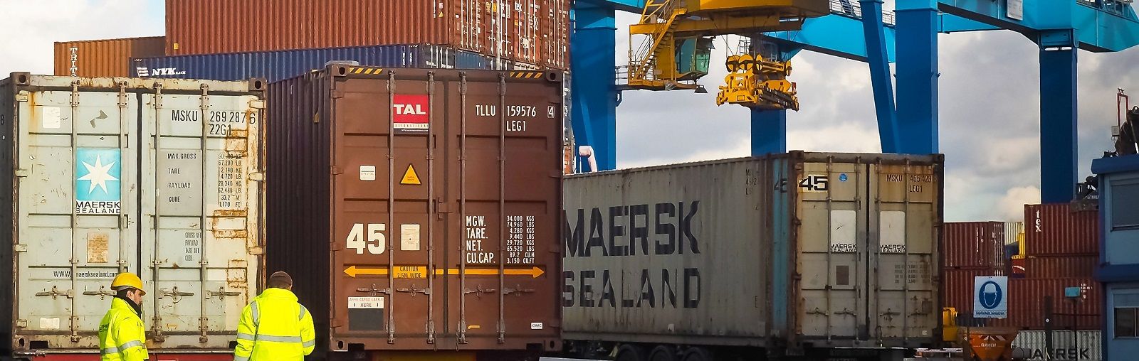Shipping port with trucks and containers | Learn Questions to Ask Your International Moving Company from AW Transportation